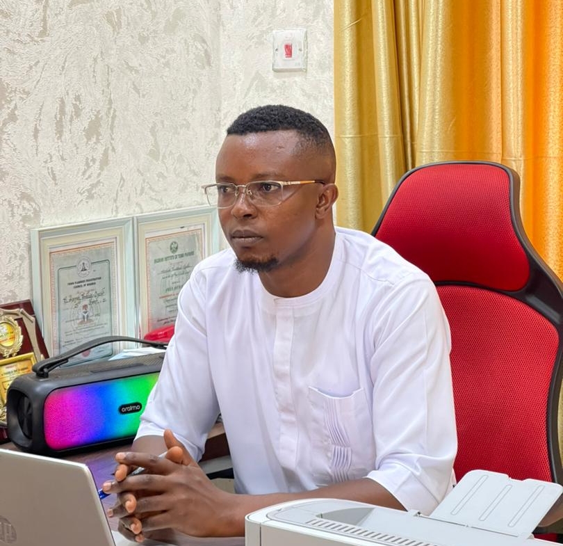 Picture of Thaddeus Ogechi Asogwa sitting and looking at a visitor in his office